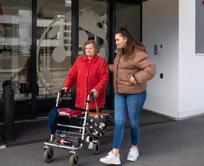 Moteris palydi vyresnio amžiaus artimąją su vaikštyne